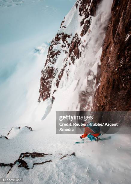 backcountry skier descends steep snow couloir - sheer stock pictures, royalty-free photos & images