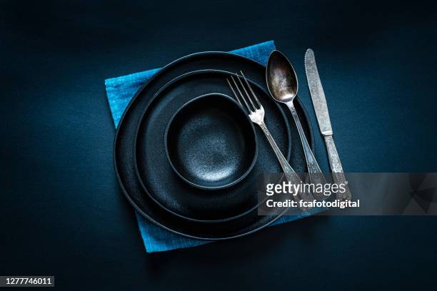 black place setting shot from above on dark table - food photography dark background blue imagens e fotografias de stock