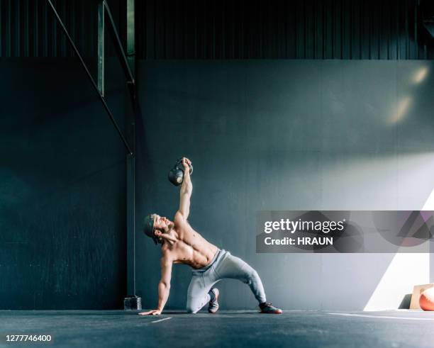 man exercising in cross training gym - kneeling stock pictures, royalty-free photos & images