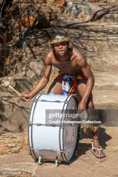 Zulu man in traditional dress playing the drum