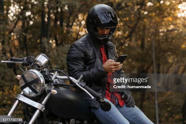 guapo ciclista macho caucásico montando su moto - motociclista fotografías e imágenes de stock