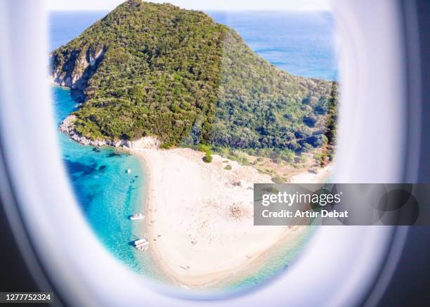 airplane window view from passenger point of view of the paradise turtle island in greece. - beach plane stock pictures, royalty-free photos & images