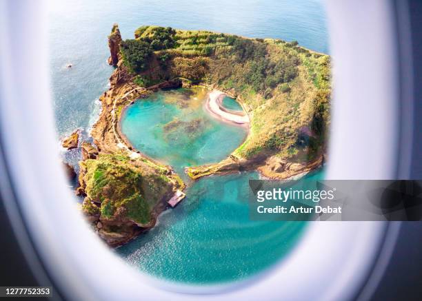 airplane window view from passenger point of view of a small island with lake inside in the azores. - airplane food stock-fotos und bilder