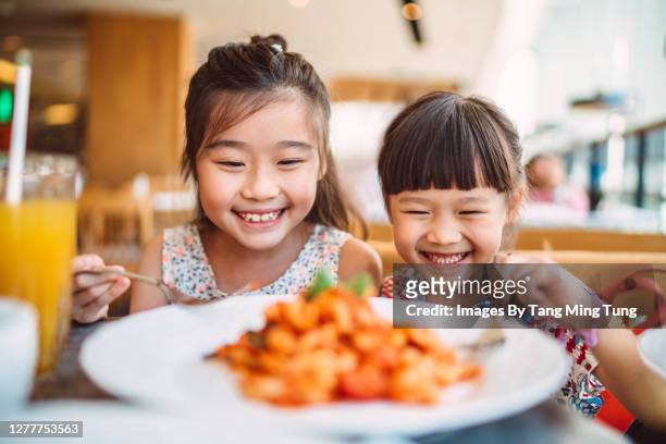 lovely little sibling having family meal in the restaurant joyfully - restaurant kids stock pictures, royalty-free photos & images