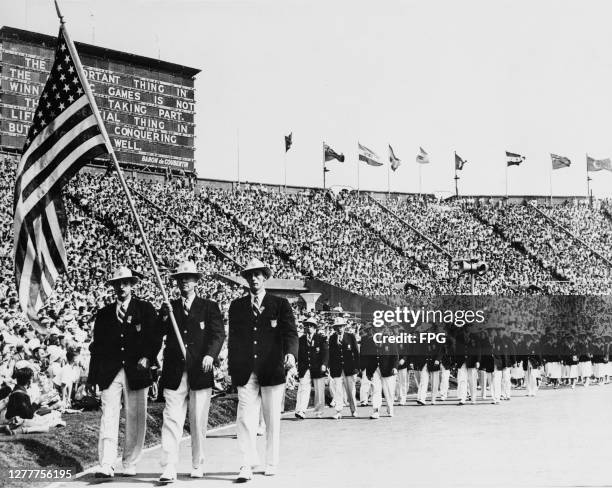The US Olympic Team march into Wembley Stadium in London at the start of the Summer Olympics, the XIVth Olympiad, 31st July 1948. On a board in the...
