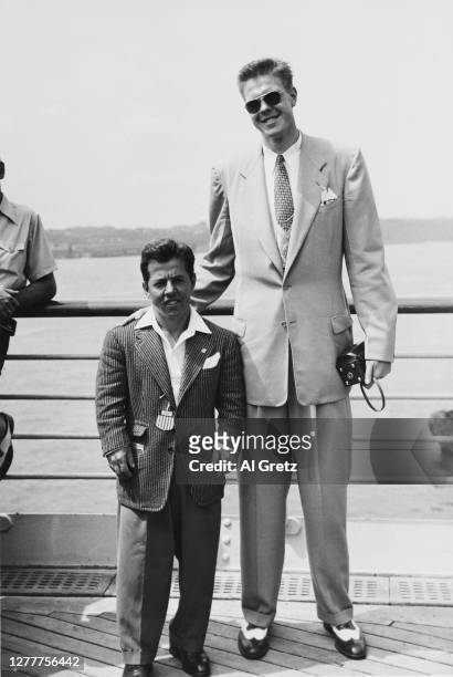 American bantamweight weightlifter Joseph DePietro with basketball champion Bob Kurland on the deck of the 'SS America', as they leave the USA for...