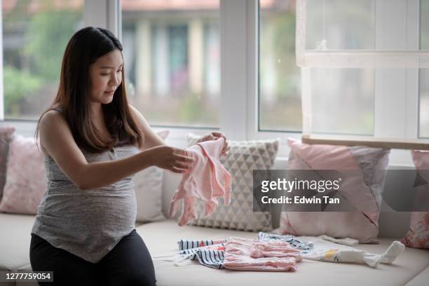 aziatische chinese zwangere vrouw die klaar voor haar pasgeboren baby maakt die babydoek en babyruimte voorbereidt - asian woman pregnant stockfoto's en -beelden