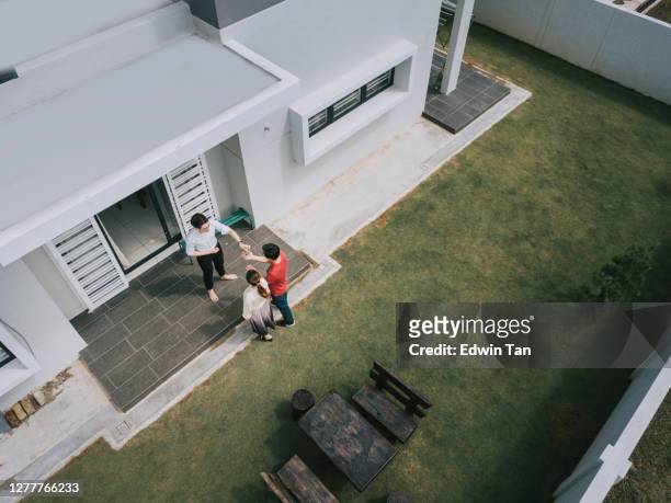asiatische chinesische paar erhalten hausschlüssel von immobilienmakler außerhalb des neuen hauses - moments daily life from above stock-fotos und bilder