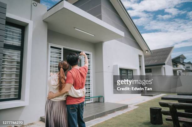 aziatische chinese jonge paar net ontvangen huissleutel voor hun nieuwe huis gelukkig - australia marriage stockfoto's en -beelden