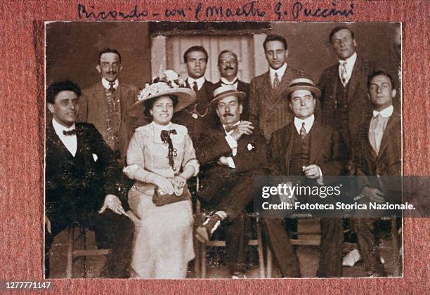 Group photo with the composer Giacomo Puccini sitting in the center with his legs crossed and a cigarette in his hand. Photograph by anonymous,...
