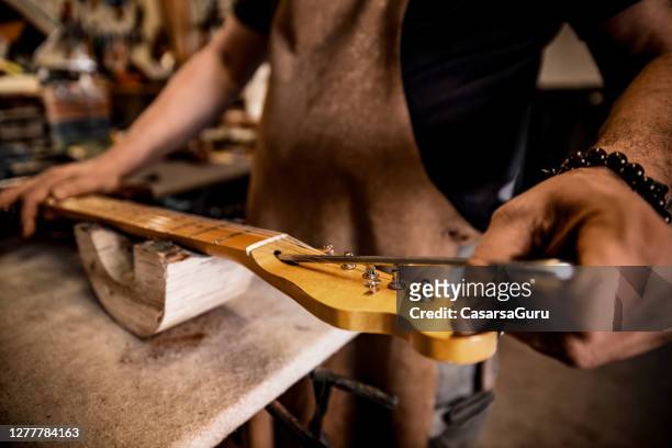close-up van timmerman die een gitaar bouwt - instrumentenmaker stockfoto's en -beelden