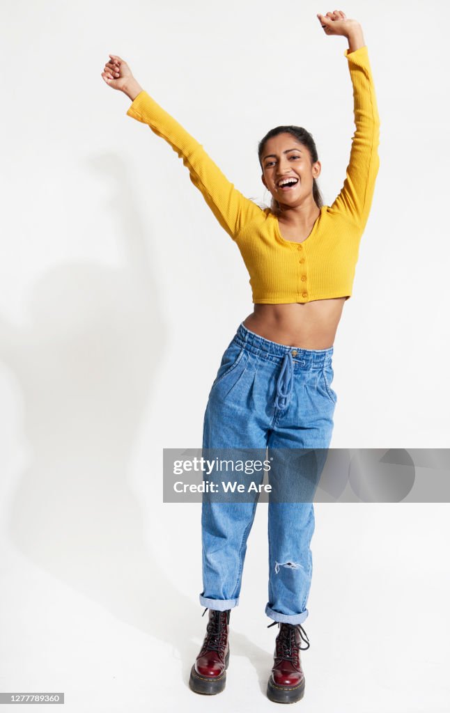 Young woman dancing with hands in the air