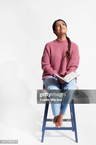 woman with book smiling - thinking student photos et images de collection