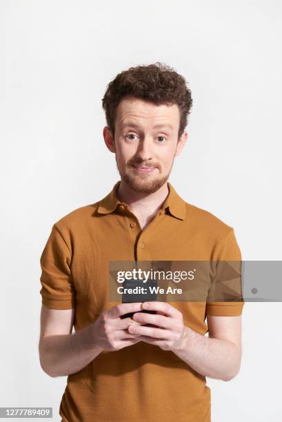 man holding mobile phone - portrait of business man looking surprised stock-fotos und bilder