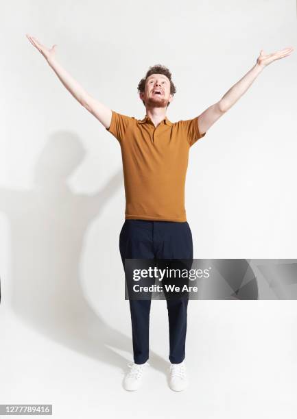 man standing with arms outstretched - indicating fotografías e imágenes de stock