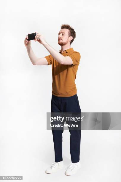 man taking photo with smartphone - man isolated bildbanksfoton och bilder