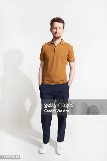 man standing casually looking at camera - figura intera foto e immagini stock