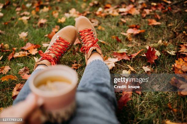 frau trinken tee im freien im herbst lässige kleidung aus der nähe von keramik teetasse - wanderschuhe stock-fotos und bilder