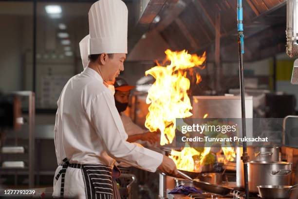 chef team preparing food in the kitchen of a hotel restaurant. - thailand hotel stock pictures, royalty-free photos & images