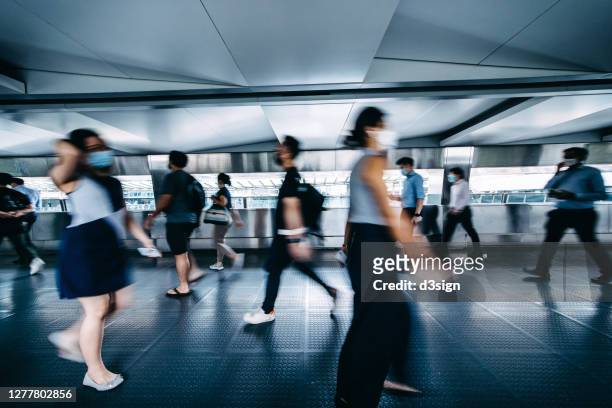 blurred motion of busy commuters with protective face mask walking on urban bridge in downtown district during rush hours in the city - hong kong street 個照片及圖片檔