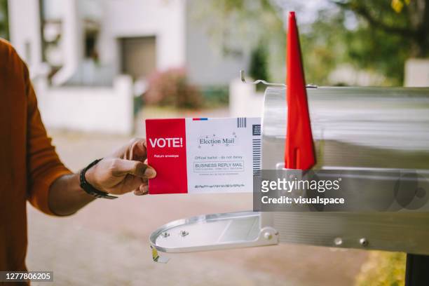 man putting voting ballot to mailbox. - voting by mail stock pictures, royalty-free photos & images