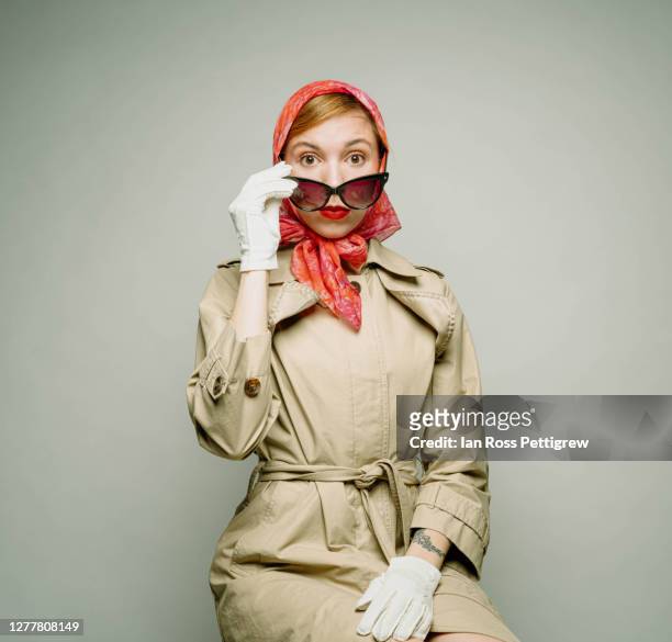 retro hipster woman wearing trench coat and kerchief on head - trench coat stock pictures, royalty-free photos & images