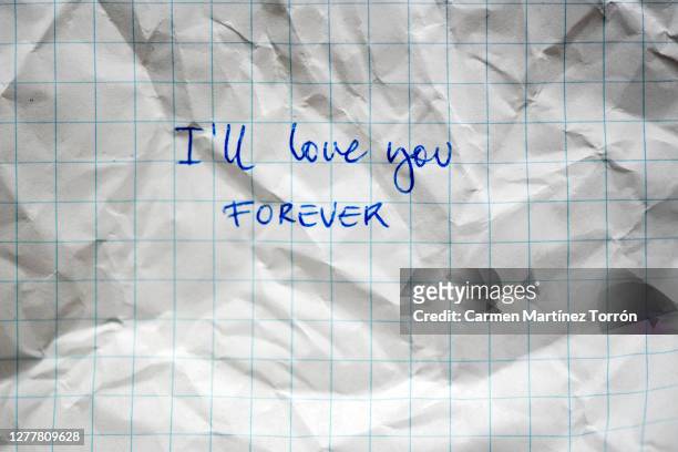 "i'll love you. forever" written on workbook. handwritten education on grid paper. written in blue paste. checkered texture. school concept. - love letter stock-fotos und bilder