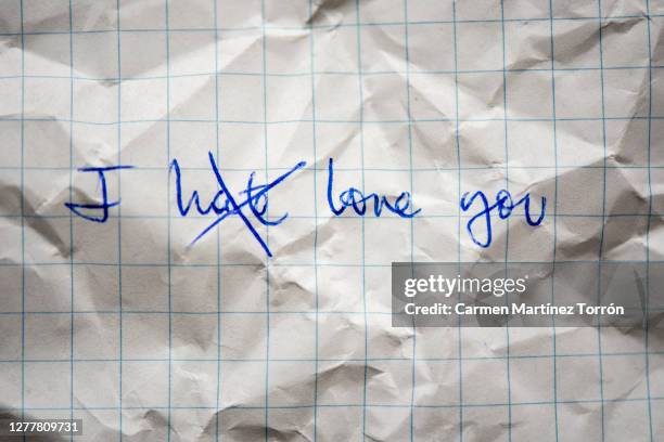written on workbook. handwritten education on grid paper. written in blue paste. checkered texture. school concept. - love hate stock-fotos und bilder