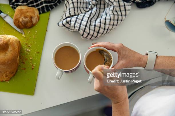 woman making a cup of tea - tea cup stock-fotos und bilder