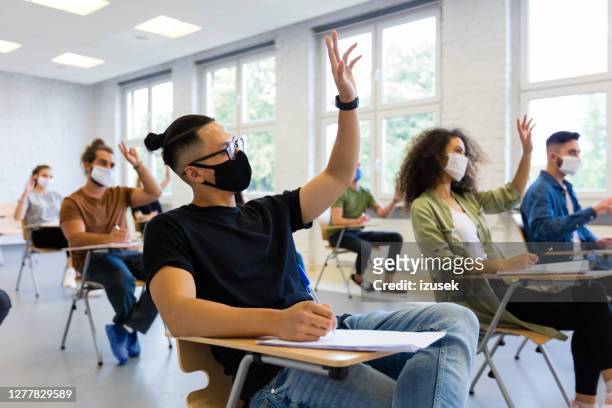 students at university during coronavirus pandemic - university covid stock pictures, royalty-free photos & images