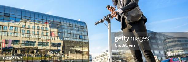 unkenntliche frau mit einem elektrischen push-scooter mit einem smartphone - einzelne frau über 40 stock-fotos und bilder