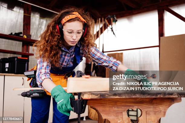 young female carpenter working with clamp. - clamp stock pictures, royalty-free photos & images