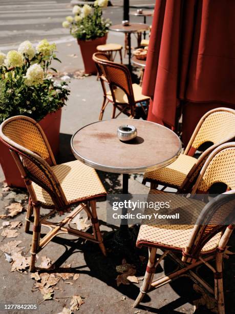 table and chairs outside a cafe in paris - frans terras stockfoto's en -beelden