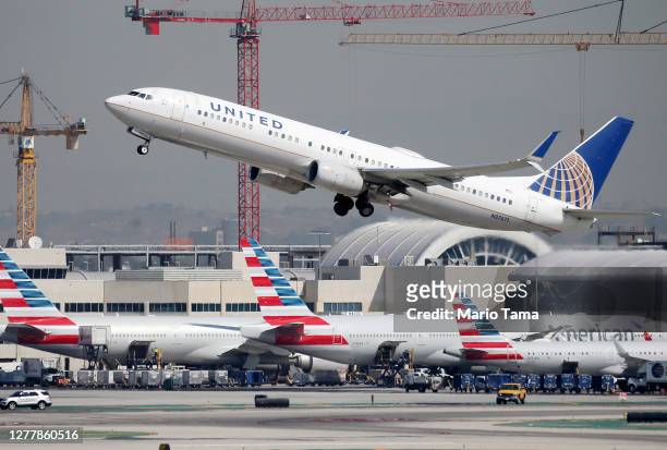 United Airlines plane takes off above American Airlines planes on the tarmac at Los Angeles International Airport on October 1, 2020 in Los Angeles,...