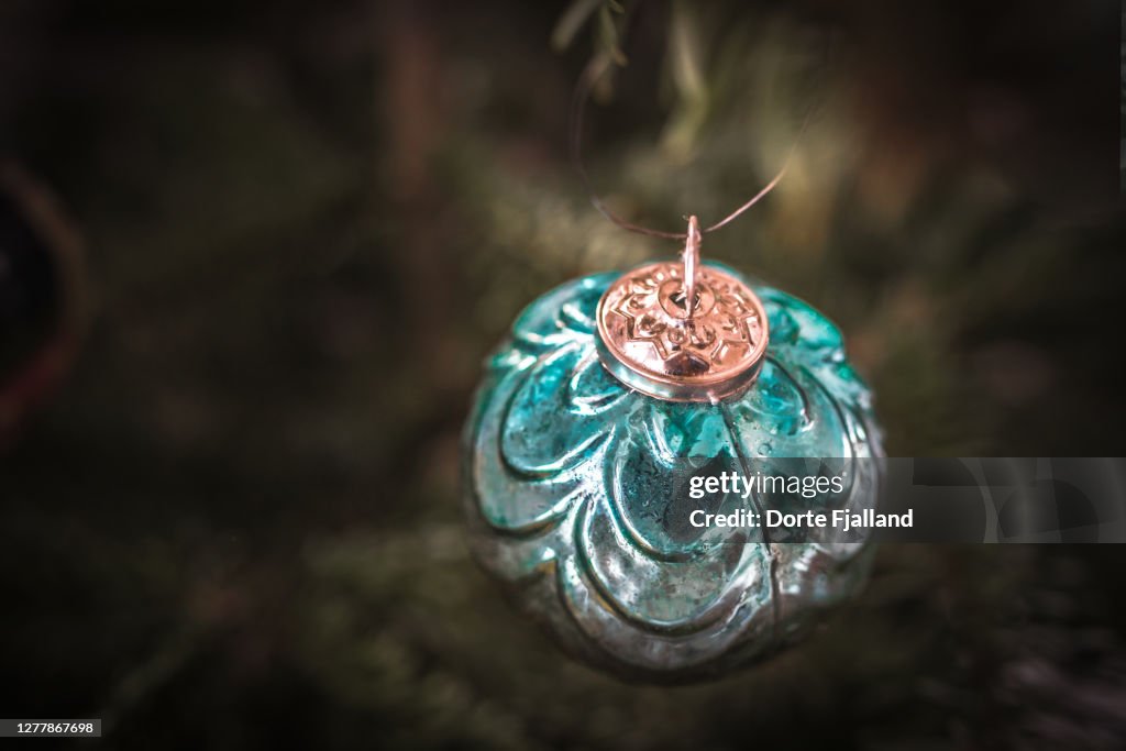 Teal green Christmas bauble with green blurred background