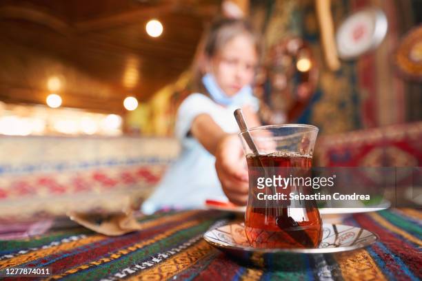 girl tourist drinking delicious traditional turkish tea in outdoor cafe at summer. - aegean turkey stock-fotos und bilder