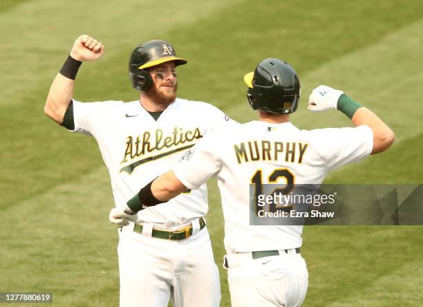 Robbie Grossman congratulates Sean Murphy of the Oakland Athletics after he hit a two-run home run against the Chicago White Sox in the fourth inning...