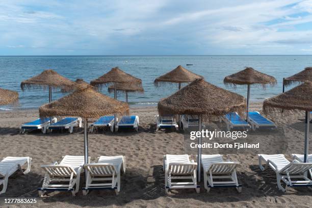 sunny, empty beach with parasols and lounge chairs - fuengirola stockfoto's en -beelden