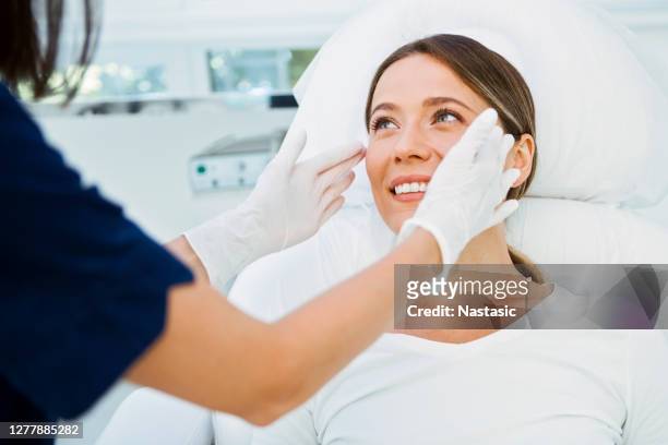 cosmetologist preparing patient for facial treatments - dermatology stock pictures, royalty-free photos & images