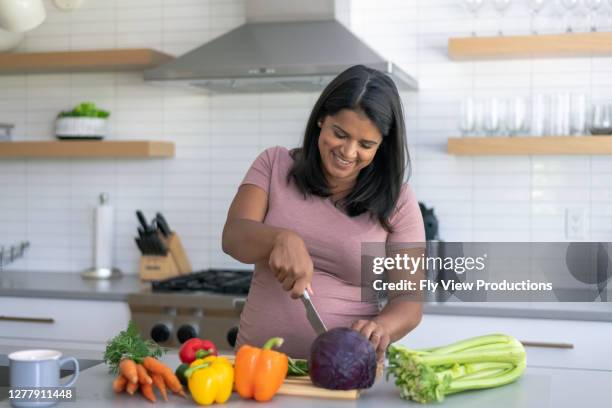 ethnic pregnant woman cooking in the kitchen - nutritionist stock pictures, royalty-free photos & images