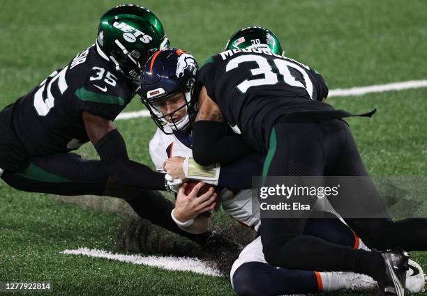 Jeff Driskel of the Denver Broncos slides and is hit by Bradley McDougald and Pierre Desir of the New York Jets drawing an unnecessary roughness call...