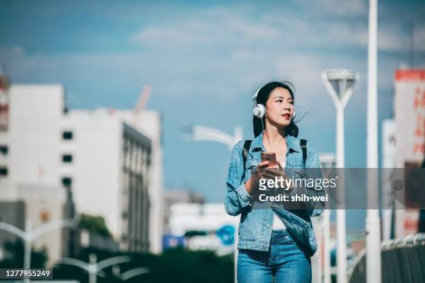 woman using smartphone walking on the street - kaohsiung stock pictures, royalty-free photos & images