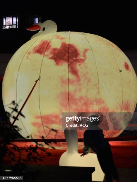 Child watches a man-made moon on Mid-Autumn Festival on October 1, 2020 in Baoding, Hebei Province of China.