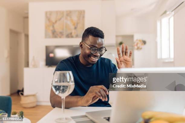 african-american man greeting his online date - zoom dating stock pictures, royalty-free photos & images