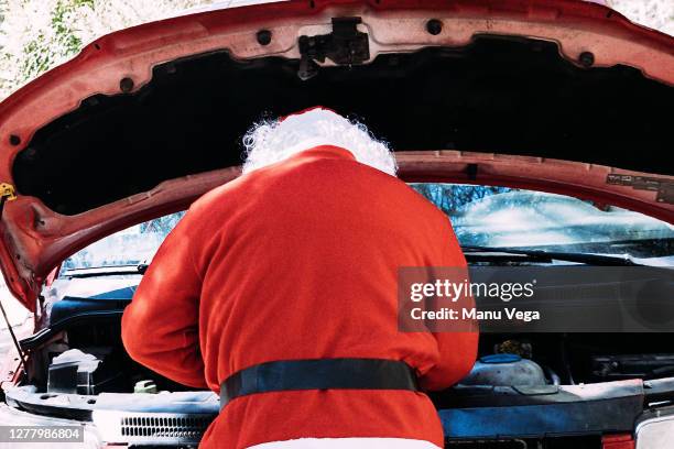 santa claus examining damaged van on country road - bonnet noel stock pictures, royalty-free photos & images