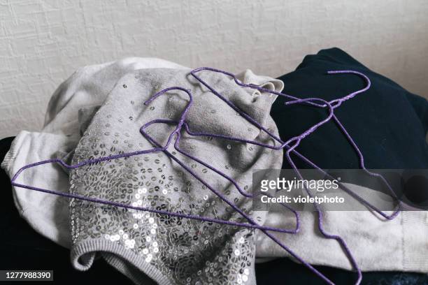 three purple hangers are on top of a pile of things - blue dress hanger stock pictures, royalty-free photos & images