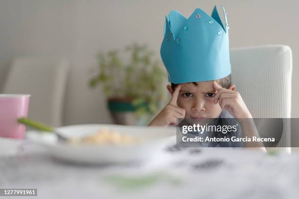 child with foam crown eats macaroons at home. king of home. - reality kings 個照片及圖片檔