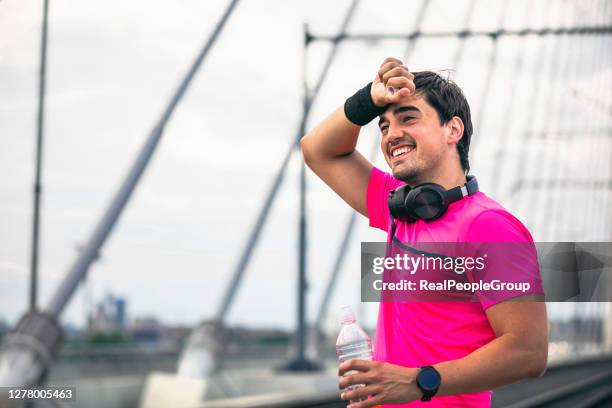 exhausted athlete taking a water break from sports training outdoors. - milk run stock pictures, royalty-free photos & images