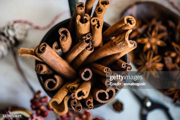 overhead view of cups of mulled wine with cinnamon and orange on a chopping board - zimt stock-fotos und bilder