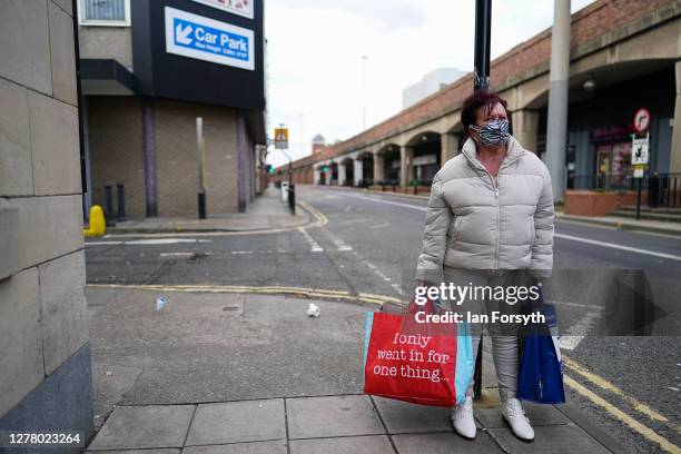 Woman wears a face mask as she waits for a lift after shopping in Middlesbrough town centre on October 02, 2020 in Middlesbrough, England. The mayor...